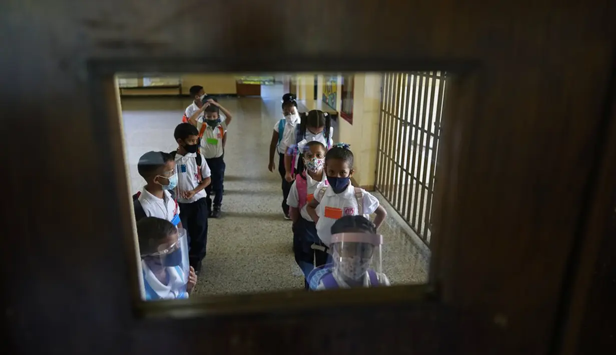 Para siswa menunggu instruksi untuk masuk ruang kelas pada hari pertama kembali ke kelas tatap muka sejak dimulainya pembatasan pandemi COVID-19 di sebuah sekolah umum di Caracas, Venezuela, 25 Oktober 2021. (AP Photo/Ariana Cubillos)