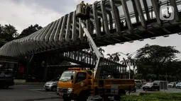 Pasukan kuning dari Dinas Bina Marga DKI Jakarta melakukan perawatan Jembatan Penyeberangan Orang (JPO) di Kawasan Sudirman, Senin (29/3/2021). Kegiatan tersebut dilakukan agar bersih terhidar dari debu serta para pemakai jembatan itu merasa aman dan nyaman. (Liputan6.com/Johan Tallo)