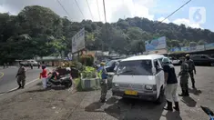 Petugas memeriksa kendaraan saat penyekatan arus lalu lintas di kawasan Ciloto, Cianjur, Jawa Barat, Jumat (17/4/2020). Pemkab Cianjur melakukan pengecekan suhu tubuh dan penyemprotan disinfektan di sejumlah titik keluar-masuk Cianjur untuk mencegah penyebaran COVID-19. (merdeka.com/Arie Basuki)