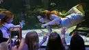 Anak-anak menonton atraksi Hales Parcels, wanita yang menjadi putri duyung di Virginia Aquarium di Virginia Beach (3/4). (AP Photo/Steve Helber)