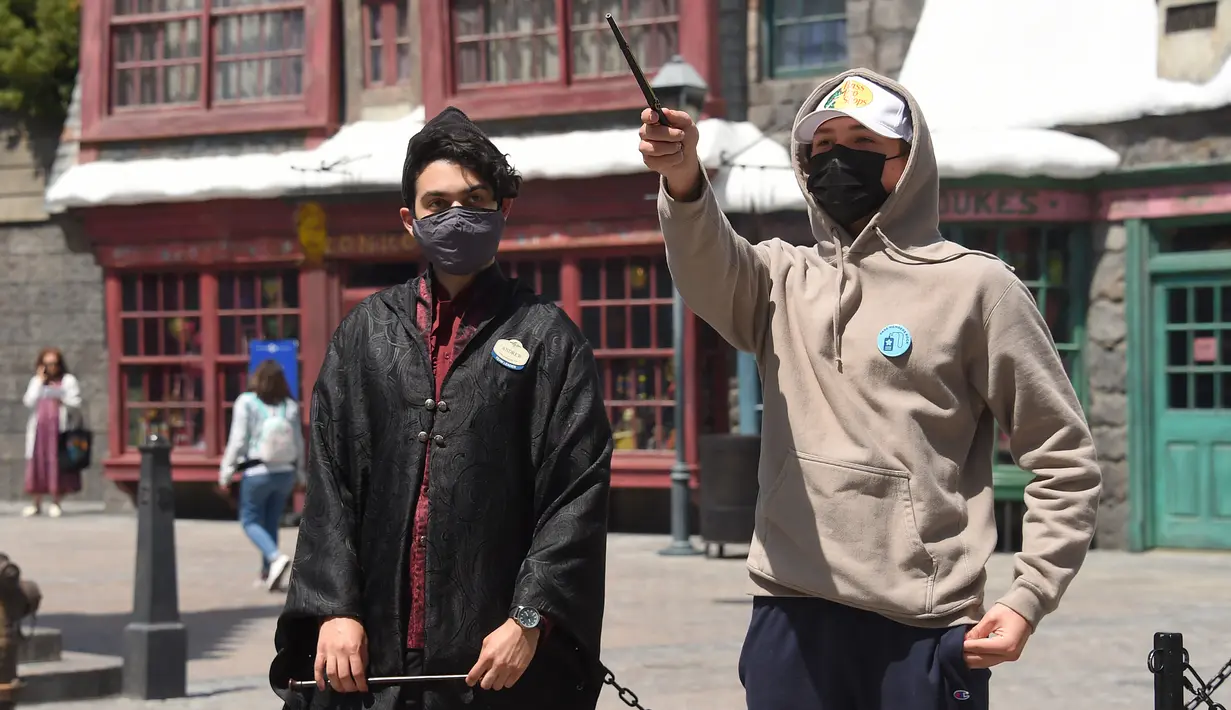 Pengunjung berada di area bertema Harry Potter pada hari pembukaan pemegang tiket musiman dan tahunan Universal Studios di Los Angeles, California, Kamis (15/4/2021). Universal Studios Hollywood akan dibuka kembali pada 16 April setelah lebih dari setahun tutup karena Pandemi. (LISA O'CONNOR/AFP)