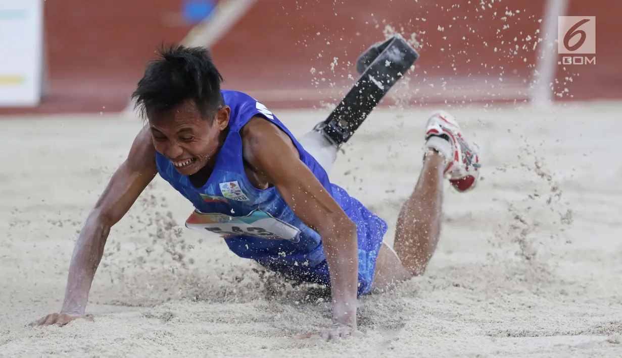 Atlet para atletik asal Myanmar, Kyaw Win Kyaw saat mendarat pada lomba lompat jauh T44, T62/T64 putra Asian Para Games 2018 di Stadion Utama Gelora Bung Karno, Jakarta, Jumat (12/10). (Liputan6.com/Helmi Fithriansyah)