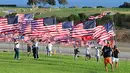 Orang-orang membantu pengibaran bendera AS untuk peringatan 20 tahun serangan 9/11 di Pepperdine University di Malibu, California, Rabu (8/9/2021). Selama 14 tahun, universitas itu memperingati tragedi 11 September 2001 dengan mengibarkan sekitar 3.000 bendera Amerika. (Frederic J. BROWN/AFP)