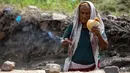 Seorang peternak lebah menggunakan asap untuk menenangkan lebah di sebuah peternakan di Kota Taez, Yaman, 28 Juni 2022. Para ahli menganggap madu Yaman sebagai salah satu yang terbaik di dunia, termasuk Royal Sidr yang terkenal karena sifat terapeutiknya. (AHMAD AL-BASHA/AFP)