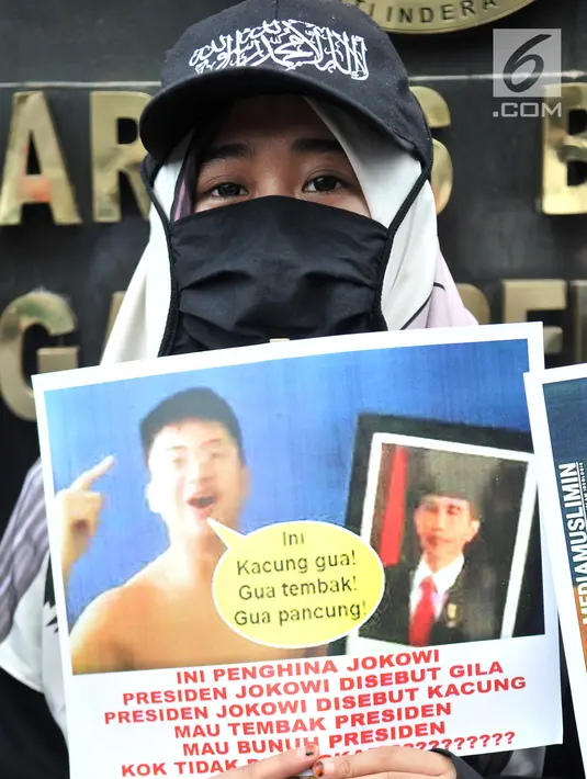Massa Laskar Pembela Islam (LPI) menunjukkan poster tuntutan saat mengawal pemeriksaan Habib Bahar bin Smith di depan Gedung Bareskrim Polri, Jakarta, Kamis (6/12). Massa LPI menuntut keadilan hukum bagi Habib Bahar. (Merdeka.com/Iqbal Nugroho)