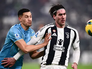Pemain Venezia, Jay Idzes, berebut bola dengan pemain Juventus, Dusan Vlahovic, dalam pertandingan pekan ke-16 Liga Italia Serie A 2024/2025 di Allianz Stadium pada Minggu (15/12/2024). Kedua tim bermain imbang dengan skor 2-2. (AFP/Marco Bertorello)