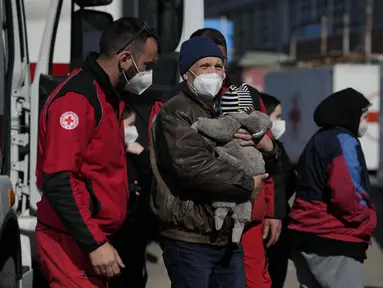 Pengungsi dari Lviv, Ukraina, tiba di markas Palang Merah di Roma, Italia pada Selasa (22/3/2022). Konvoi kendaraan Palang Merah yang membawa 80 orang, sebagian besar orang tua dan sakit tiba pada Selasa di Roma. (AP Photo/Alessandra Tarantino)