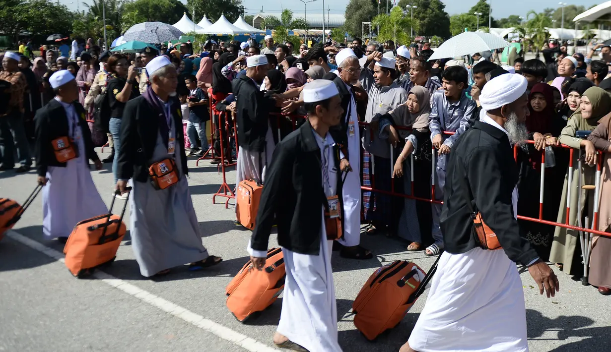 Jemaah calon haji berjalan menuju pesawat penerbangan khusus saat akan bertolak ke Tanah Suci Mekah di Bandara Provinsi Narathiwat, Thailand, Kamis (4/7/2019). Jutaan umat muslim dari penjuru dunia akan bertolak menuju Mekah untuk melangsungkan ibadah haji. (Madaree TOHLALA/AFP)