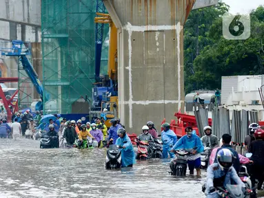 Pengendara mendorong motornya melintasi banjir di Jalan Raya Bekasi, Jakarta Timur, Selasa (25/2/2020). Banjir akibat hujan yang melanda Bekasi sejak Selasa (25/2) dini hari memutus beberapa titik jalan raya di wilayah setempat. (merdeka.com/Imam Buhori)