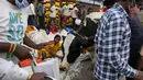Seekor sapi mengambil seikat bunga dari penjual di pasar grosir di Bengaluru, India, Rabu (13/4/2022). Orang-orang telah kembali beraktivitas normal setelah pihak berwenang mencabut pembatasan COVID-19 termasuk mengenakan masker wajah di tempat-tempat umum. (AP Photo/Aijaz Rahi)