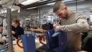 Proses merapikan bagian tas di bengkel produsen barang-barang mewah Hermes di Allenjoie, Perancis, Kamis (5/4). Hermes merupakan brand fashion eksklusif asal Prancis. (SEBASTIEN BOZON/AFP)