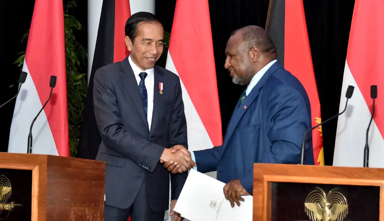 Presiden Indonesia Joko Widodo atau Jokowi (kiri) dan Perdana Menteri Papua Nugini James Marape (kanan) berjabat tangan pada konferensi pers setelah pertemuan bilateral di APEC Haus, Port Moresby, Papua Nugini, Rabu (5/7/2023). (ANDREW KUTAN/AFP)