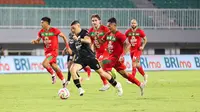 Pemain Dewa United, Alexis Messidoro, mencoba keluar dari kepungan pemain Persebaya Surabaya dalam pertandingan Dewa United melawan Persebaya Surabaya pada pekan ke-24 BRI Liga 1 di Stadion Pakansari, Kabupaten Bogor, Jumat (21/2/2025) malam WIB. (Bola.com/Abdul Aziz)