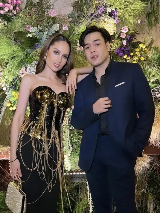 Cinta Laura tampil mengenakan atasan korset model blink-blink dengan aksen rantai keemasan dipadukan rok panjang hitam sambil membawa handbag manik-manik goldnya. [@jejesoekarno]