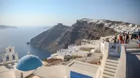 Santorini adalah persinggahan utama dalam pengalaman berlayar di Yunani. Namun karena sebagian dari pulau ini sudah hampir penuh, para pejabat sedang mempertimbangkan pembatasan. (Aris Oikonomou / AFP)