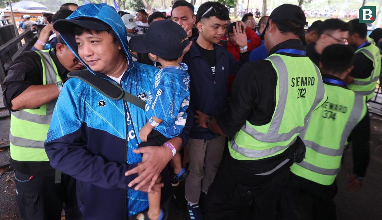 Pendukung Persib Bandung yang lolos dari pemeriksaan melanjutkan perjalanan menuju ke dalam stadion sebelum laga leg 1 final Championship Series BRI Liga 1 2023/2024 melawan Madura United di Stadion Si Jalak Harupat, Bandung, Minggu (26/05/2024). (Bola.com/Muhammad Iqbal Ichsan)