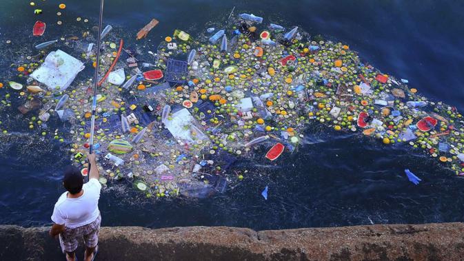 Seorang pria memancing di pantai Laut Tengah di Beirut, Lebanon di antara berbagai sampah plastik. (AP)