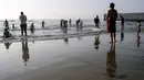 Orang-orang mengunjungi pantai di Playas de Tijuana dekat perbatasan AS-Meksiko di Tijuana Meksiko, Sabtu (3/10/2020). Akhir pekan ini pantai di Playas de Tijuana dibuka kembali dengan pembatasan pengunjung, setelah ditutup sejak Maret lalu guna mencegah penyebaran Covid-19. (Guillermo Arias/AFP)
