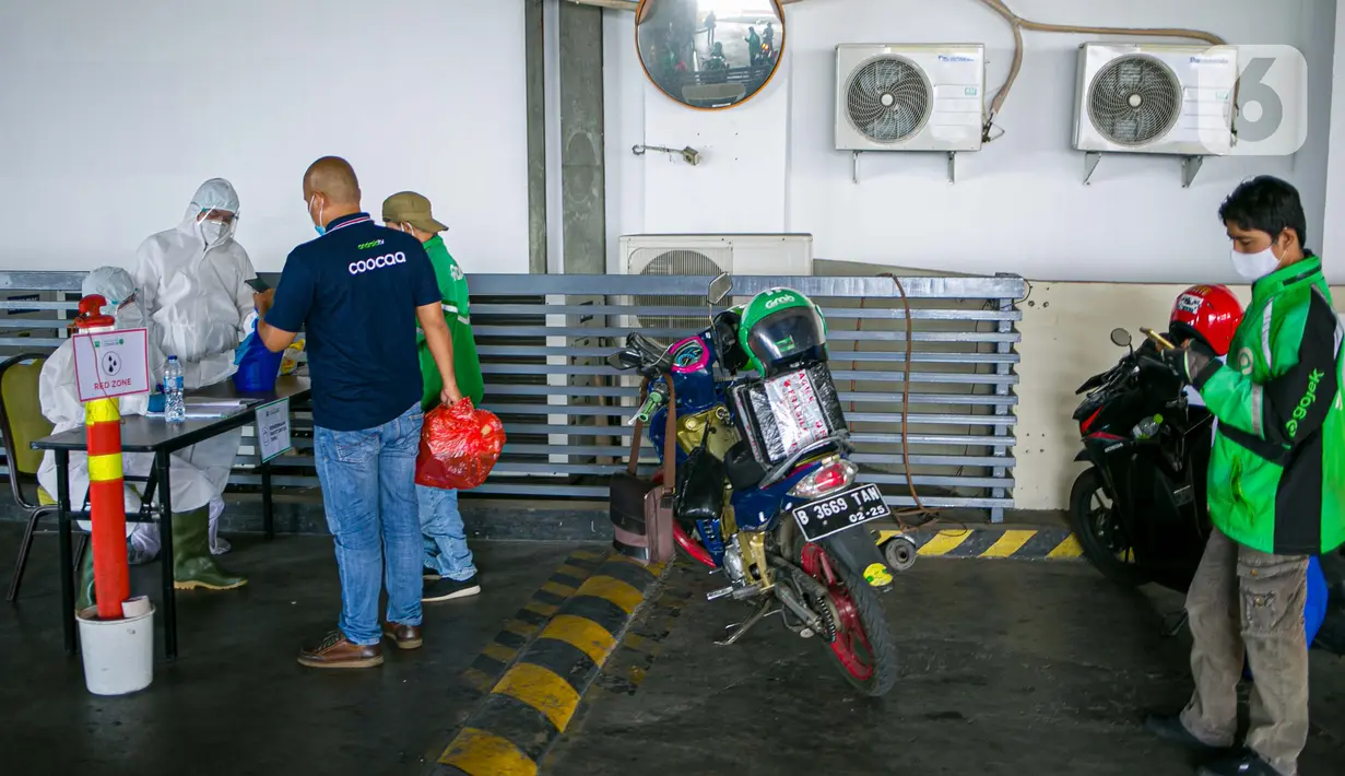 Petugas Hotel Ibis Styles Mangga Dua Square Jakarta menerima barang kiriman untuk pasien Covid-19 berstatus orang tanpa gejala (OTG) yang sedang melakukan isolasi mandiri, Kamis (1/10/2020). Dalam menjalankan tugasnya, petugas hotel selalu memakai APD lengkap. (Liputan6.com/Faizal Fanani)