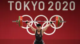 Lifter Indonesia Rahmat Erwin Abdullah saat berlaga dalam cabang olahraga angkat besi 73 kg putra pada Olimpiade Tokyo 2020 di Tokyo, Jepang, Rabu (28/7/2021). Rahmat Erwin meraih perunggu setelah memiliki total angkatan 342 kg. (AP Photo/Luca Bruno)
