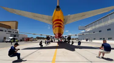 Anggota tim sekuat-tenaga untuk menarik pesawat DHL Boeing 757 sejauh 20 meter di Safi Aviation Park, Malta pada 1 Mei 2019. Kegiatan tarik pesawat tersebut merupakan rangkaian dalam rangka untuk penggalangan dana amal. (REUTERS/Darrin Zammit Lupi)