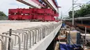 Kereta melintas dekat proyek pembangunan jalur dwiganda atau double-double track (DDT) di Jakarta, Jumat (12/4). Proyek pembangunan DDT ditargetkan rampung pada tahun 2021. (Liputan6.com/Herman Zakharia)