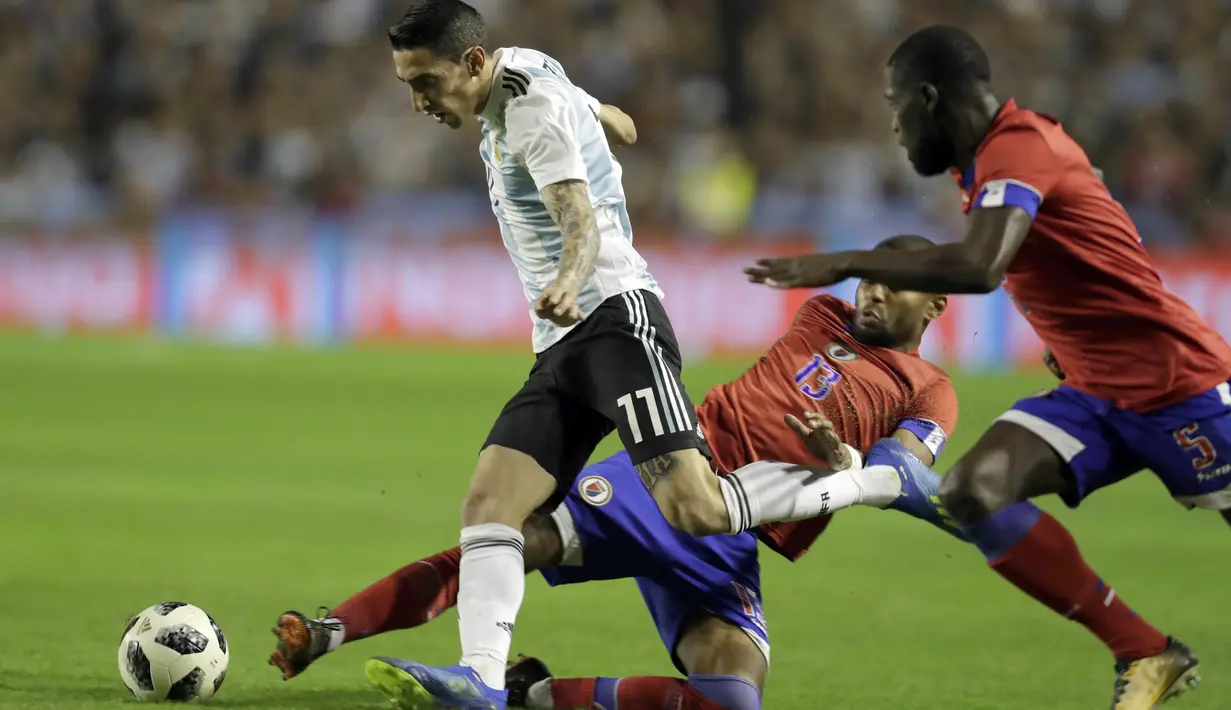 Pemain Argentina, Angel Di Maria melewati adangan dua pemain Haiti pada laga uji coba di Buenos Aires, Argentina, (29/5/2018). Argentina menang 4-0. (AP/Victor R. Caivano)