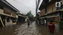 Warga beraktivitas diarea lingkungannya yang tergenang banjir di Jalan Hang Lekir, Kebayoran Lama, Jakarta Selatan, Rabu (1/1/2020). Banjir tersebut disebabkan karena tingginya intensitas hujan yang mengguyur sejak Selasa (31/12/2019). (Liputan6.com/Johan Tallo)