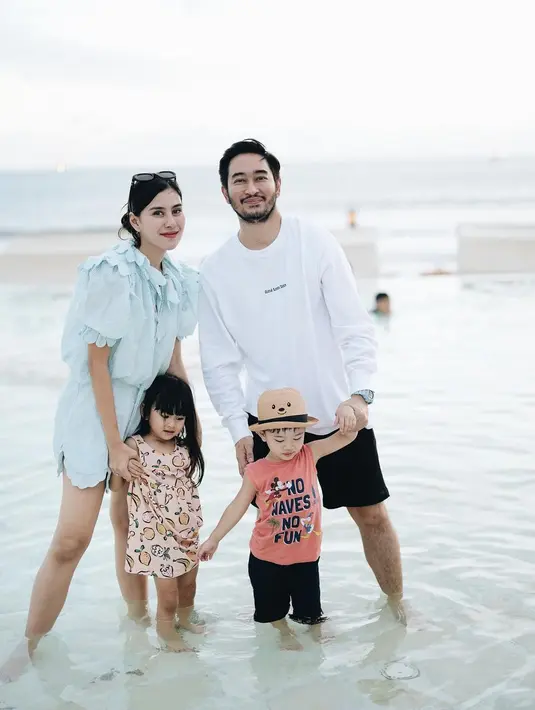 Potret liburan ala keluarga Syahnaz Sadiqah. Syahnaz tampil mengenakan setelan atasan lengan pendek dan bawahan serasi berwarna biru muda yang lembut. Outfitnya cantik dengan garis leher, lengan, dan garis celana yang manis. [Foto: Instagram/syahnazs]