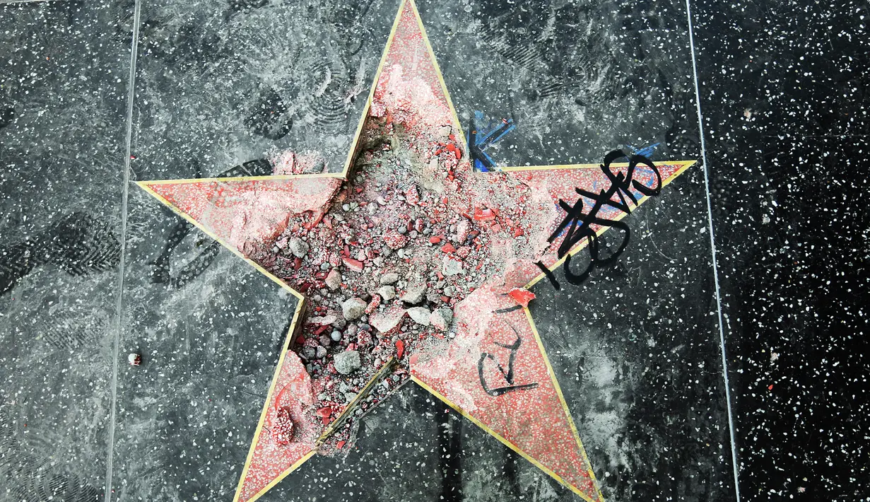 Bintang di Walk of Fame Hollywood atas nama Presiden Amerika Serikat (AS) Donald Trump yang rusak di Los Angeles, Rabu (25/7).  Perusakan Hollywood Walk of Fame Donald Trump itu dilakukan seorang pria menggunakan kapak dalam aksinya. (AP/Reed Saxon)