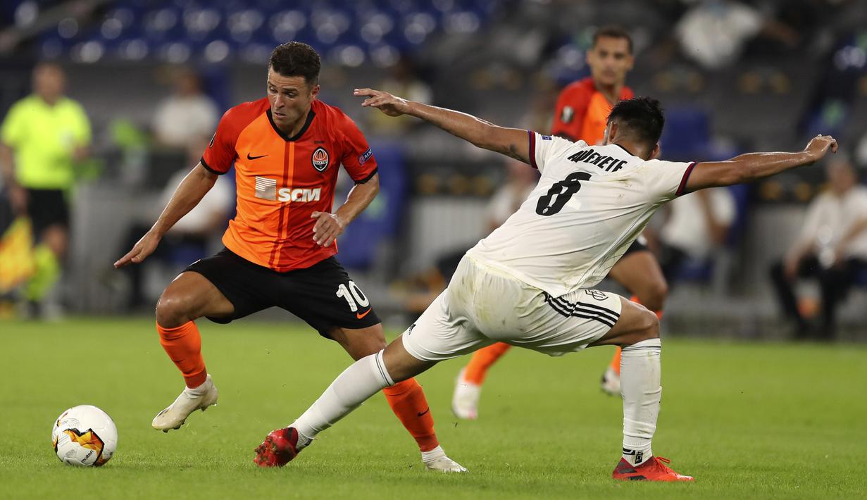Pemain Shakhtar Donetsk Junior Moraes (kiri) mencoba melewati pemain Basel Omar Alderete pada pertandingan perempat final Liga Europa di Veltins-Arena, Gelsenkirchen, Jerman, Selasa (11/8/2020). Shakhtar Donetsk menang 4-1. (Lars Baron/Pool Photo via AP)