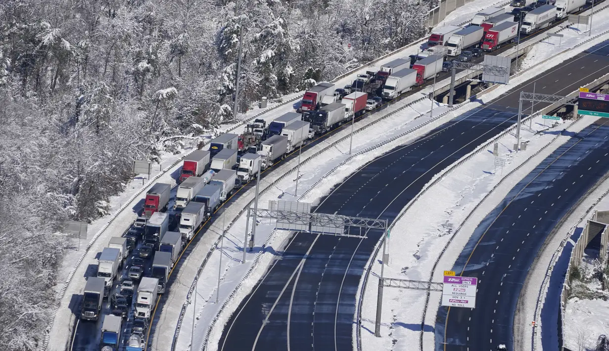 Mobil dan truk terdampar di bagian Interstate 95 dekat Quantico, Virginia, Selasa (4/1/2022). Salju tebal menimbulkan kekacauan di Washington, DC, menyebabkan ratusan pengemudi terdampar di jalan raya utama di Virginia. (AP Photo/Steve Helber)