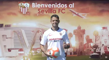 Penyerang baru Sevilla, Javier Hernandez 'Chicharito' berpose dengan jersey klub barunya selama presentasi resminya di Sport City of Sevilla (2/9/2019). Eks penyerang Manchester United dan Real Madrid ini digaet Sevilla dengan mahar yang dikabarkan mencapai 8 juta euro. (AFP Photo/Cristina Quicler)