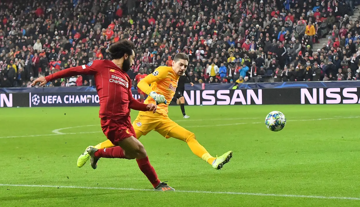 Pemain Liverpool Mohamed Salah (kiri) mencetak gol ke gawang Red Bull Salzburg pada pertandingan Grup E Liga Champions di Salzburg, Austria, Selasa (10/12/2019). Liverpool menang 2-0 dan lolos ke babak 16 besar Liga Champions. (JOE KLAMAR/AFP)