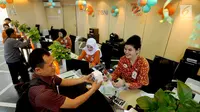 Teller memberikan bunga mawar dan souvenir kepada nasabah di Kantor Cabang BNI Tebet, Jakarta (5/7). Kegiatan dalam rangka HUT ke 72 BNI mengusung tema BNITu Digital. (Merdeka.com/Arie Basuki)