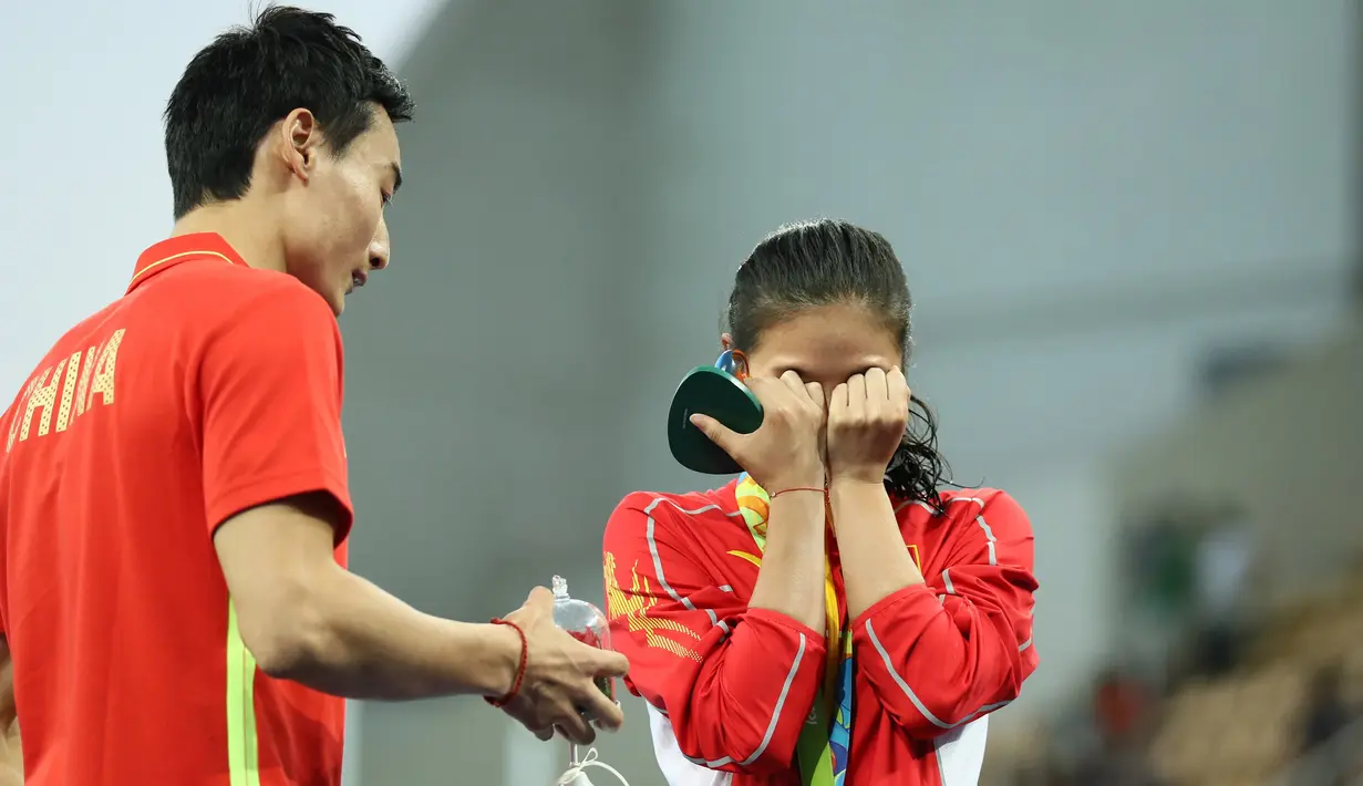 Atlet loncat indah Putri asal Tiongkok, He Zi terharu saat dilamar kekasihnya Qin Kia di atas panggung, saat pengalungan medali perak di ajang Lompat Indah 3 meter pada Olimpiade 2016 di Rio de Janeiro, Brasil, (14/8). (REUTERS/Stefan Wermuth)