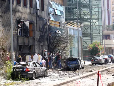 Warga dan petugas saat memeriksa kerusakan yang terjadi di Bank Blom pasca ledakan di Beirut, Lebanon (13/6). Bom meledak di sekitar Bank Blom pada Minggu (12/6) malam. (REUTERS/Jamal Saidi)