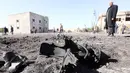 Petugas memeriksa lokasi bom truk yang meledak di sebuah sekolah polisi di kota Zliten, wilayah barat Libya, Kamis (7/1). Belum ada yang mengaku bertanggung jawab terkait serangan bom yang menewaskan sedikitnya 50 orang tersebut. (AFP PHOTO/MAHMUD Turkia)