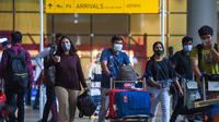 Penumpang yang tiba meninggalkan terminal di Bandara Internasional Chhatrapati Shivaji Maharaj di Mumbai, India pada 1 Desember 2021. (PUNIT PARANJPE / AFP)