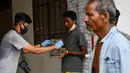 Seorang pria Rohingya (tengah) saat menjalani prosedur identifikasi oleh kepolisian Aceh di pusat penampungan sementara bekas kantor Imigrasi Punteuet di Lhokseumawe, Aceh Utara (26/6/2020). (AFP Photo/CHAIDEER MAHYUDDIN)