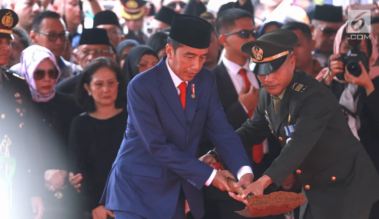 Presiden RI Joko Widodo atau Jokowi saat menimbun tanah ke liang lahat almarhumah Ani Yudhoyono di TMP Kalibata, Jakarta, Minggu (2/6/2019). Ani Yudhoyono meninggal dunia di National University Hospital Singapura pada 1 Juni 2019 karena kanker darah. (Fimela.com/Deki Prayoga)
