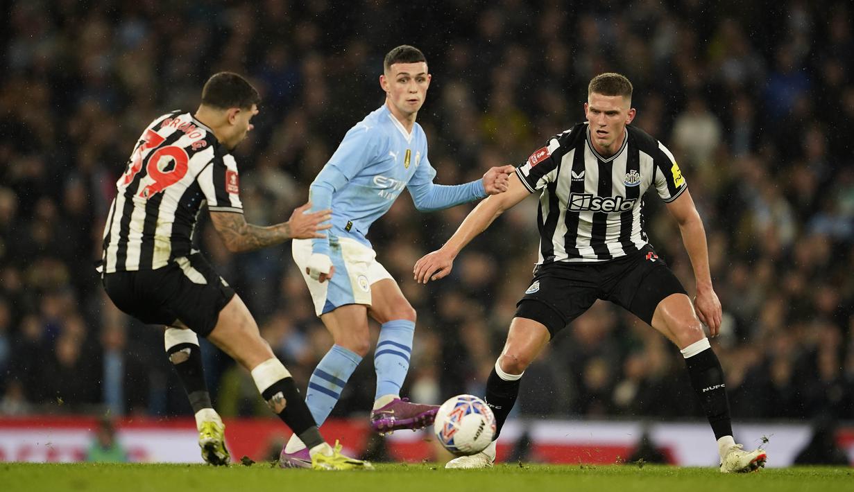 Pemain Manchester City, Phil Foden, dijaga ketat pemain Newcastle United pada laga Piala FA di Stadion Etihad, Minggu (17/3/2024). (AP Photo/Dave Thompson)