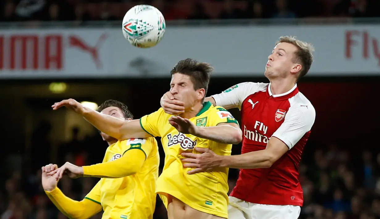 Pemain Arsenal, Rob Holding berusaha menyundul bola dari pemain Norwich City, Timm Klose pada lanjutan Piala Liga Inggris di Emirates Stadium, Rabu (25/10). Edward Nketiah memborong gol Arsenal saat mengalahkan Norwich City 2-1. (AP/Alastair Grant)
