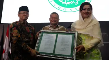 Dirut PT Kustodian Sentral Efek Indonesia (KSEI), Friderica Widyasari Dewi menerima salinan fatwa secara simbolis dari Sekretaris DSN-MUI, Anwar Abbas di Gedung BEI, Senin (1/4). KSEI secara resmi memperoleh fatwa dari DSN-MUI terkait Proses Bisnis Atas Layanan Jasa (Liputan6.com/Johan Tallo)