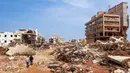 Seorang pria berjalan melewati puing-puing bangunan yang disebabkan oleh banjir bandang di Derna, Libya timur, pada 11 September 2023. Banjir bandang di Libya timur menewaskan lebih dari 2.300 orang di kota pesisir Mediterania, Derna. (AFP)
