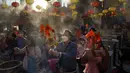 Warga yang mengenakan masker membakar dupa saat mereka berdoa di Kuil Wong Tai Sin, Hong Kong, Jumat (12/2/2021). Meskipun perayaan Imlek biasanya dilakukan dengan cara bervariasi di seluruh dunia, maka tahun ini sangat berbeda karena pandemi COVID-19. (AP Photo/Kin Cheung)