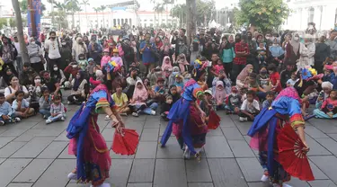 Warga menyaksikan hiburan dalam festival seni dan budaya di kawasan wisata Kota Tua, Jakarta, Sabtu (17/9/2022).  Festival bertajuk #IniJakarta yang digelar oleh Pemprov DKI Jakarta tersebut berlangsung mulai 16 sampai 18 September 2022. (Liputan6.com/Herman Zakharia)