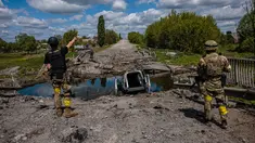 Prajurit unit pasukan khusus Ukraina Kraken berbicara dengan seorang pria di jembatan yang hancur di jalan dekat desa Rus'ka Lozova, utara Kharkiv, pada 16 Mei 2022. Ukraina mengatakan pasukannya telah menguasai kembali wilayah di Perbatasan Rusia dekat kota terbesar kedua di negara itu Kharkiv, yang terus-menerus diserang sejak invasi Moskow dimulai. (Dimitar DILKOFF / AFP)