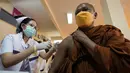 Petugas kesehatan menyuntikan vaksin kepada biksu Buddha di Wat Srisudaram di Bangkok, Thailand (30/7/2021). Thailand sedang berjuang untuk menahan wabah terbarunya yang dipicu oleh varian Delta yang sangat menular, dengan infeksi dan kematian yang meroket. (AP Photo/Sakchai Lalit)