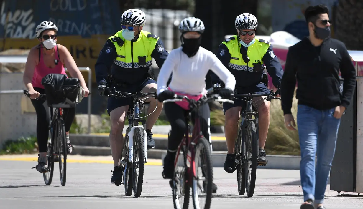 Polisi berpatroli dengan sepeda di sepanjang St Kilda Esplanade di Melbourne (26/10/2020). Pejabat kesehatan Australia melaporkan tidak ada kasus virus corona baru atau kematian di negara bagian Victoria. (AFP Photo/William West)